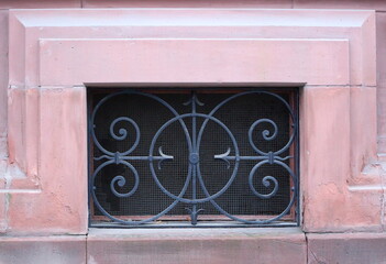 A basement window with a metal barrier