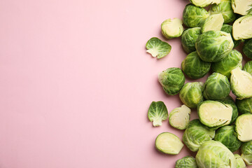 Fresh Brussels sprouts on pink background, flat lay. Space for text