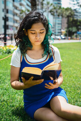 mujer leyendo un libro en el parque.