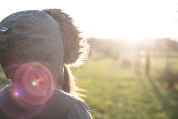 Isolated woman looking towards a better future in full back light with lens flair