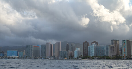 Ocean view of Honolulu and Waikiki on the Island of Oahu under tropical rain clouds.