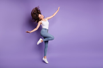 Fototapeta na wymiar Full body photo of brown haired carefree girl jump up wear white tank-top copyspace isolated on violet color background