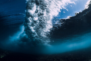 Breaking wave with foam and bubbles underwater. Transparent water