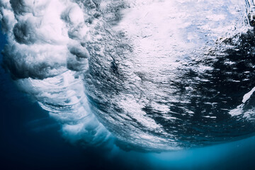 Breaking wave with foam and bubbles underwater. Transparent water