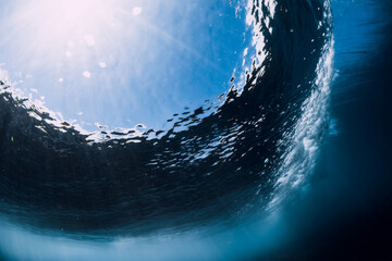 Breaking wave with foam and bubbles underwater. Transparent water