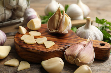 Fresh sliced and whole garlic on wooden table, closeup. Organic product