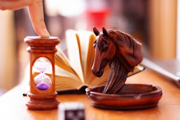 still life with horse head ashtray dice book and sandglass on a table