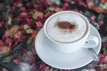 white cup of coffee on floral background