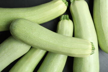 Raw green zucchinis on black slate table, closeup