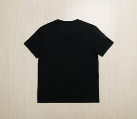 Black T-shirts mockup template on wooden floor.