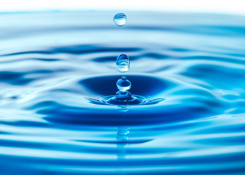 Dark blue water droplets splash in the water surface  close up. Creating a perfect water wave