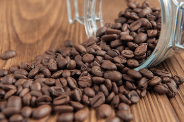 Heap of coffee beans on textured wooden table