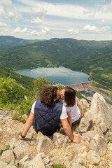 Naklejka premium Couple kissing while taking a hiking break at mountain viewpoint
