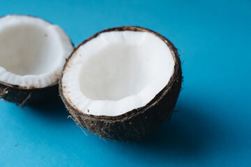 Coconut cut in half on blue background, broken and ready for eating,Close up 
