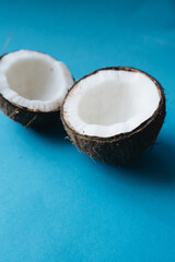 Coconut cut in half on blue background, broken and ready for eating,Close up 