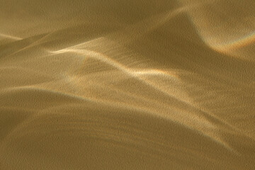 Background with refractive optical effect shadows and shining
lines of light on a gold-colored...