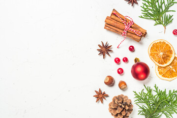 Christmas composition made from natural decorations. Winter tree, spices, cones and nuts at white marble background. Flat lay image with copy space.