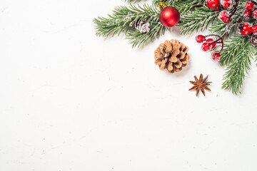 Christmas background with fir tree and decorations at white table. Top view with copy space.