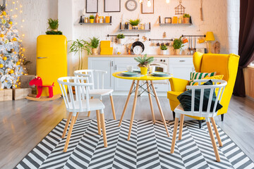 Trendy fashion luxury interior design in Scandinavian style of studio apartment with bright yellow furniture and decorated with new year lights.