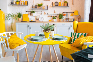Trendy fashion luxury interior design in Scandinavian style of studio apartment with bright yellow furniture and decorated with new year lights.