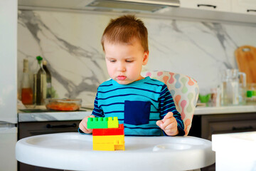 Boy kid playing to a plastic toy blocks, designer of children's toys. Educational toys. Early learning.