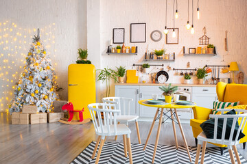 Trendy fashion luxury interior design in Scandinavian style of studio apartment with bright yellow furniture and decorated with new year lights.