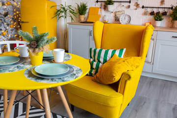 Trendy fashion luxury interior design in Scandinavian style of studio apartment with bright yellow furniture and decorated with new year lights.