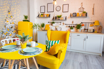 Trendy fashion luxury interior design in Scandinavian style of studio apartment with bright yellow furniture and decorated with new year lights.