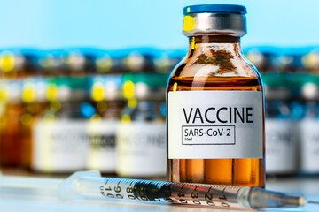 Covid-19 vaccine bottle with a syringe on lab table