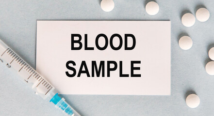 Blood SAMPLE, a white pill and a syringe, are next to the business card.