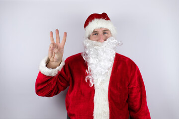 Fototapeta na wymiar Man dressed as Santa Claus standing over isolated white background showing and pointing up with fingers number three while smiling confident and happy