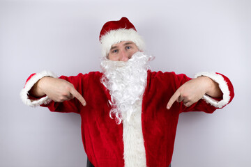 Fototapeta na wymiar Man dressed as Santa Claus standing over isolated white background looking confident with smile on face, pointing oneself with fingers proud and happy.