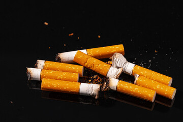 Cigarette butts on black background close up