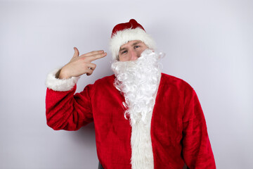 Fototapeta na wymiar Man dressed as Santa Claus standing over isolated white background Shooting and killing oneself pointing hand and fingers to head like gun, suicide gesture.