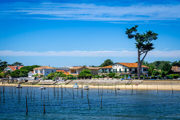 Yacht boat in the blue sea in front of the sand dune in Bassin d'arcachon to visit oysters farm
