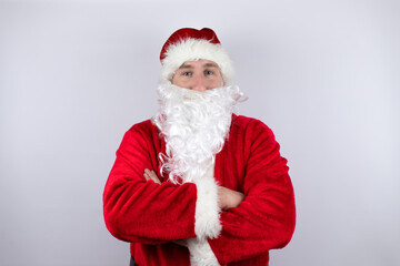 Man dressed as Santa Claus standing over isolated white background looking confident at the camera with arms crossed