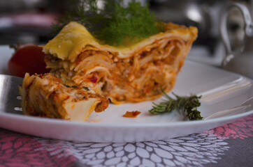 Delicious homemade lasagna with minced meat, tomato sauce and dill on a wooden rustic background. Homemade italian food
