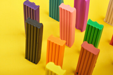 colored plasticine on yellow background copy space