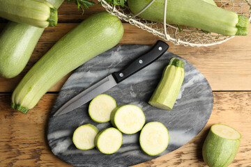 Green ripe zucchinis on wooden table, flat lay