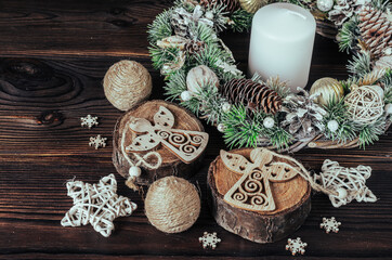 Christmas wreath, candle, tree cuts, stars, snowflakes, wooden figurines of angels on a wooden background.