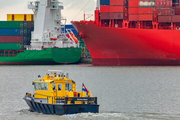 Dutch pilot boat in Port of Rotterdam with container freight ships in the background