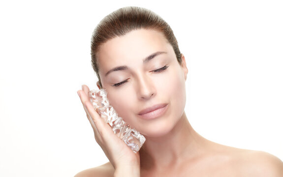 Spa Woman with healthy clean skin aplying ice cubes on face. Skincare Beauty Treatments