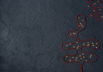 Red decorations in the form of a Christmas tree and gold stars on a black background.