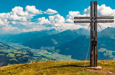Beautiful alpine view with a summit cross at the famous Panoramabahn Kitzbueheler Alpen, Salzburg, Austria