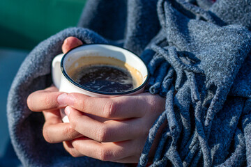 Coffee cup in young girl hands. Cup of hot drink in hands. Cold weather concept.