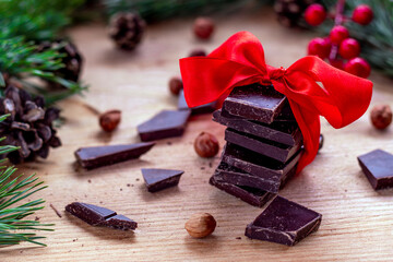 Home made dark chocolate bar with red bow on white background. 