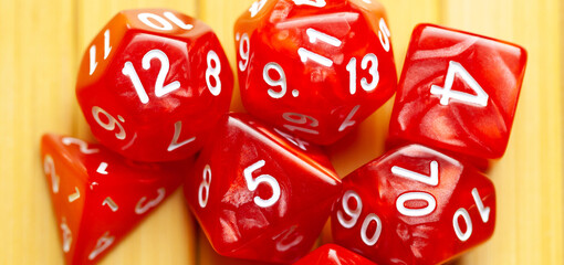 Lots of red RPG game dice extreme closeup wide shot, banner. Role playing board games symbol, simple polyhedral dice set scattered, showing random numbers. Nerd, geek culture, math probability concept