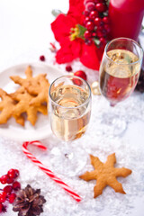 Champagne glasses with cranberry, snowflake shaped cookies. candy cane and Christmas decoration. Christmas and New Year concept.