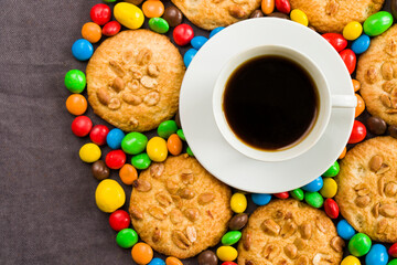 Cup of black espresso coffee and chocolate, candy and cookies on the gray background