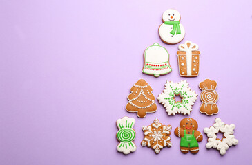 Christmas tree shape made of delicious gingerbread cookies on lilac background, flat lay. Space for text
